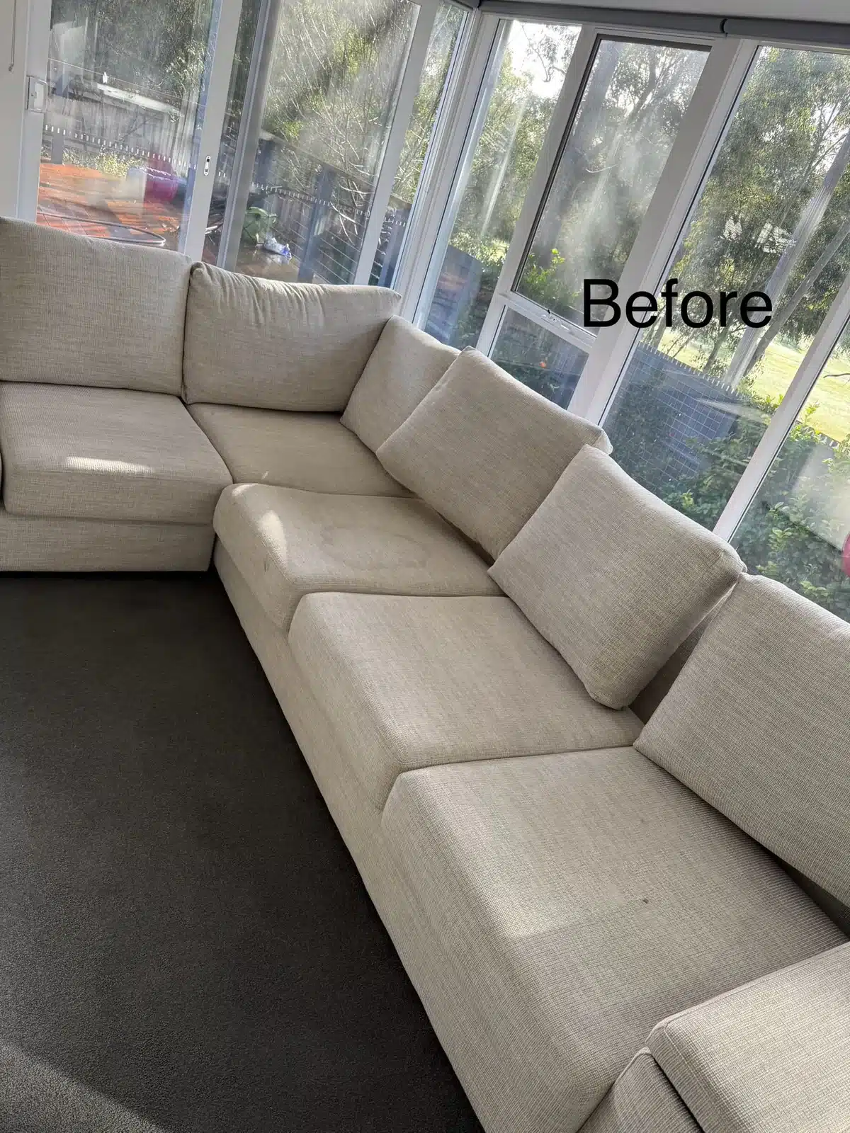 Before: cream L-shaped modular lounge cleaned in a sunroom