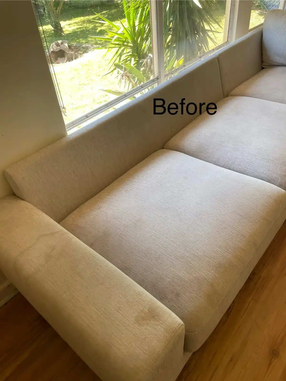 Before: cream fabric sofa with soiled arms and seats cleaned